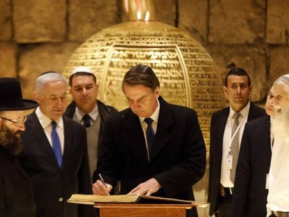Bolsonaro assina livro ao lado do primeiro-ministro israelense Benjamin Netanyahu e do rabino Shmuel Rabinovitch em visita a sinagoga na Cidade Velha de Jerusalém, no dia 1º de abril