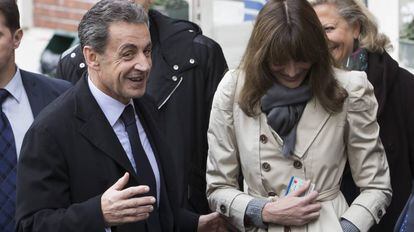 O ex-presidente francês Nicolás Sarkozy e sua esposa, Carla Bruni-Sarkozy, saem de um despacho de voto durante o primeiro turno das eleições primárias