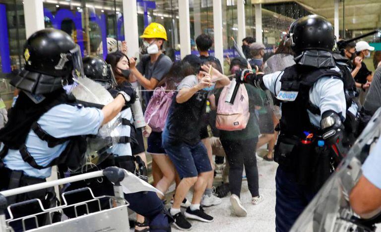 Polícia usa gás de pimenta contra os manifestantes do aeroporto de Hong Kong.