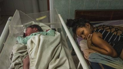 Rosa Sabina Briceno, de 22 anos, junto a seu bebê no ambulatório de Santo Domingo, após dar a luz em um táxi.