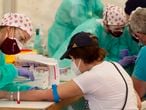 Personal sanitario extrae sangre a un hombre en un test de covid en Torrejón de Ardoz en Madrid, en mayo.