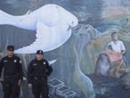 Policías salvadoreños detrás de un mural que hace alusión a la guerra civil que sufrió El Salvador.