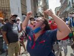 A woman shouts pro-government slogans as anti-government protesters march in Havana, Cuba, Sunday, July 11, 2021. Hundreds of demonstrators took to the streets in several cities in Cuba to protest against ongoing food shortages and high prices of foodstuffs. (AP Photo/Ismael Francisco)