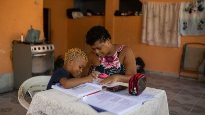 Uma mãe ensina a tarefa escolar ao filho em casa, no Rio de Janeiro.