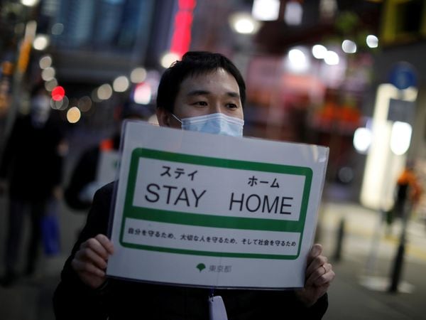A staff members of the Tokyo metropolitan government wearing a protective face mask march as he calls for people to stay home after the government announced the state of emergency for the capital and some prefectures following the coronavirus disease (COVID-19) outbreak, at an entertainment and amusement district in Tokyo, Japan April 14, 2020.  REUTERS/Issei Kato