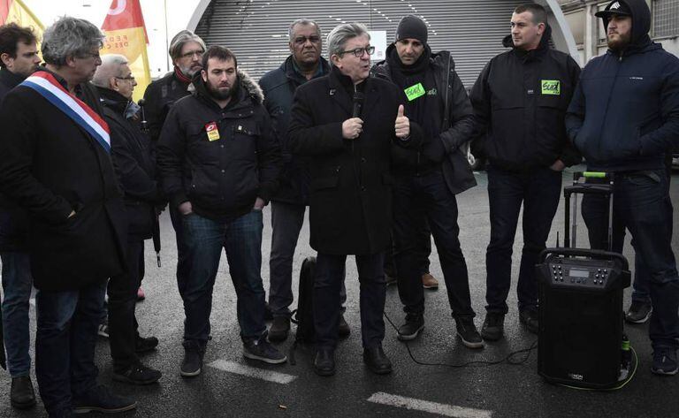 O líder esquerdista Jean-Luc Mélenchon fala com um grupo de ferroviários em Paris.