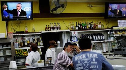 Trabalhadores assistem em um bar a um pronunciamento de Michel Temer da TV.