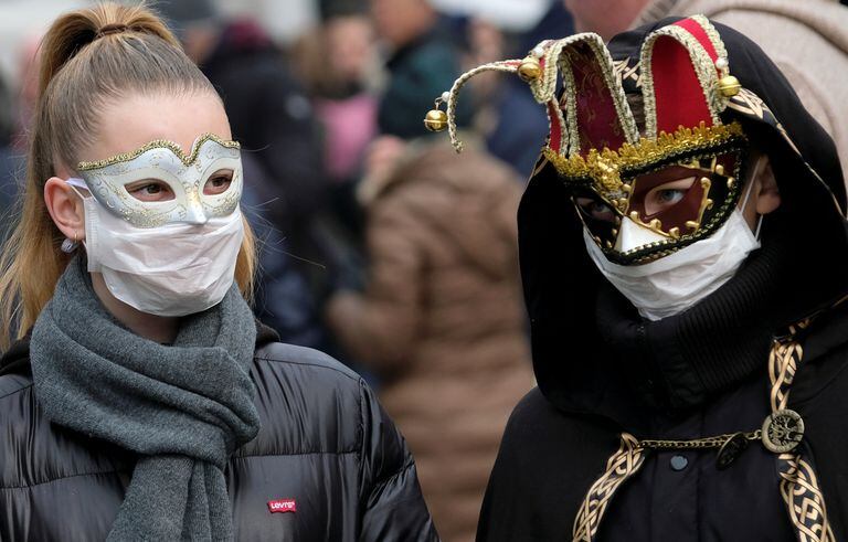 Masked carnival revellers wear protective face masks at Venice Carnival, which the last two days of, as well as Sunday night's festivities, have been cancelled because of an outbreak of coronavirus, in Venice, Italy February 23, 2020.  REUTERS/Manuel Silvestri