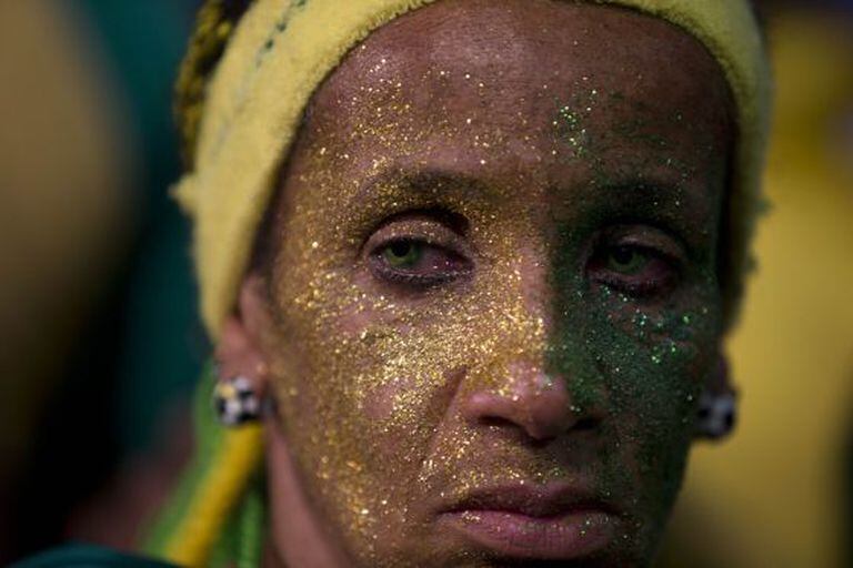 Torcedora brasileira assiste ao jogo desolada.