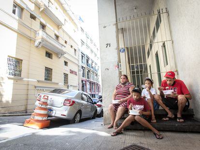 Maxwell Oliveira e Verônica Medeiros almoçam, junto com seus dois filhos, após receber doação de marmita de uma ONG, em São Paulo.