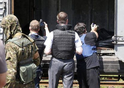 Inspetores da OSCE fotografam os corpos na estação de Torez.