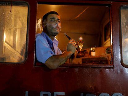 Motorista de trem fuma shisha em uma feira em Damasco.