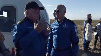 El actor William Shatner, a la izquierda, habla con Jeff Bezos al bajarse de la nave espacial cerca de Van Horn, Texas
