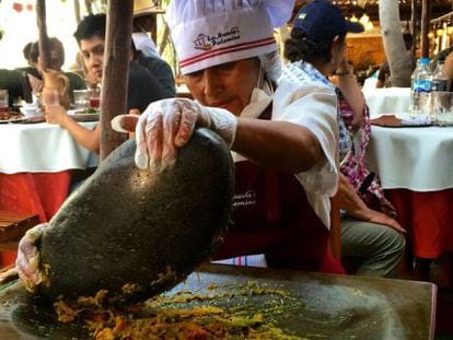 Cozinheira esmaga alimentos num ‘batán’ no restaurante La Nueva Palomino, em Arequipa.