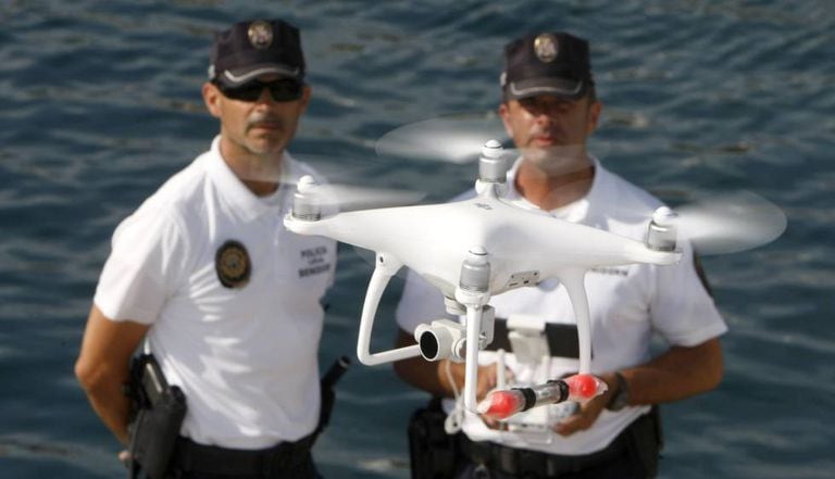 Agentes da polícia local de Benidorm e o drone usado para monitorar o litoral.