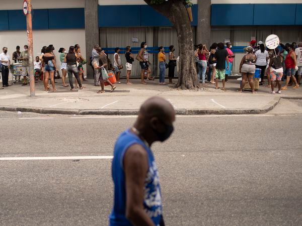 People out of work wait outside a government-run bank having technical problems to distribute their aid money amid the new coronavirus pandemic's affect on the economy in Rio de Janeiro, Brazil, Tuesday, April 28, 2020. (AP Photo/Silvia Izquierdo)