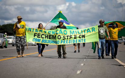 Manifestantes carregam faixa em que defendem o fechamento do STF e do Congresso, em Brasília. 