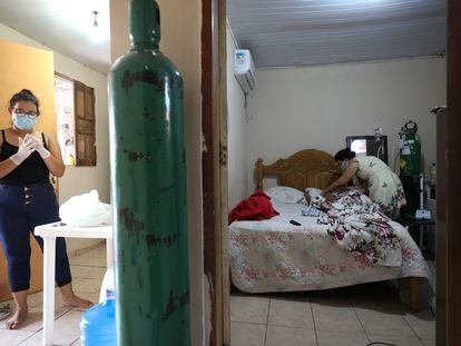 Enfermeira Angela Maria Reis se prepara para tomar conta de Erystenys Reis da Costa, 45, contagiada pela covid-19, em Manaus.