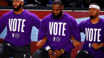 Anthony Davis, LeBron James e Quinn Cook, dos Lakers, com o lema “Vote” em suas camisetas.