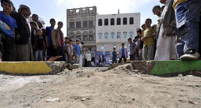 Curiosos no local da explosão de um artefato em Sanaa.