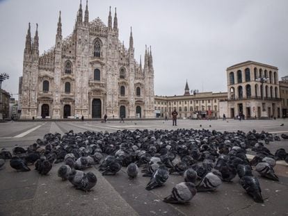Pombos e poucas pessoas na praça do Duomo, a principal de Milão, deserta devido ao coronavírus.