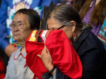 Idosa indígena canadense segura uma cópia do relatório final sobre o genocídio sofrido por seu povo, no dia 3 de junho, no Quebec.