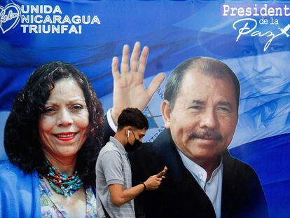 Um homem caminha diante de um cartaz de propaganda que mostra o presidente da Nicarágua, Daniel Ortega, e a recém-nomeada ‘copresidenta’ Rosario Murillo.