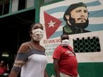 People pass by an image of late Cuban President Fidel Castro amid concerns about the spread of the coronavirus disease (COVID-19), in Havana, Cuba, July 19, 2020. REUTERS/Alexandre Meneghini