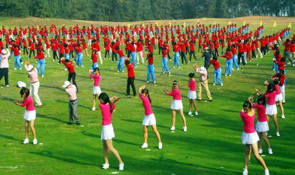 Centenas de jogadores treinam golfe em Hainan (China).